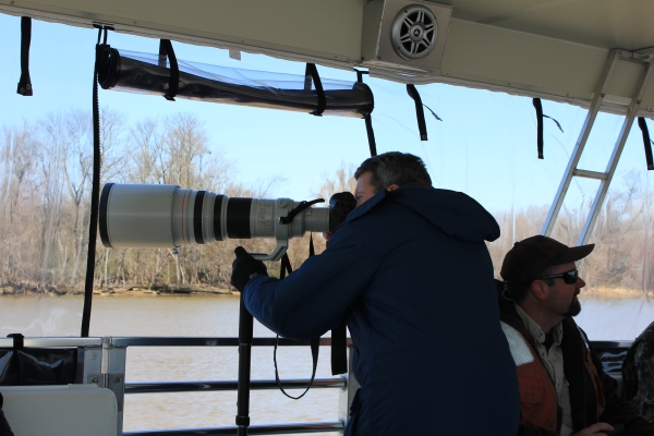 Wildlife watching over river from boat through spotting scope
