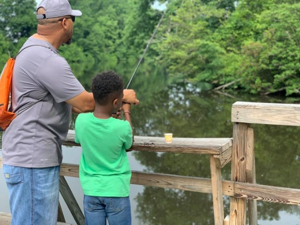 father and son fishing off pier