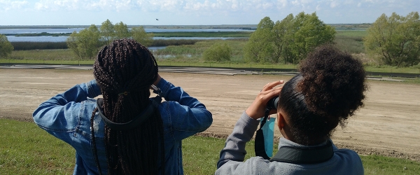 Two girls looking through binoculars