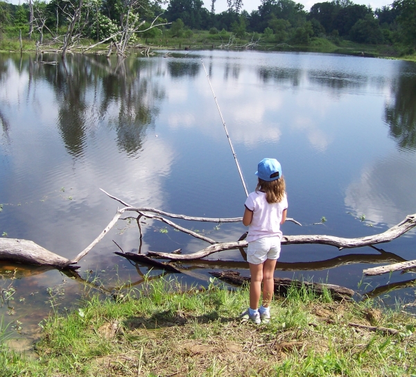 Girl bank fishing on pond