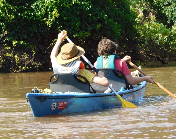 Two boys paddling a kayak canoe hybrid boat o bayou