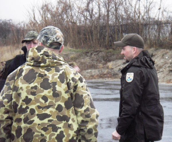 A law enforcement officer speak with hunters.