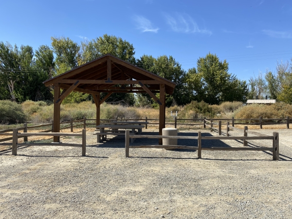 Covered picnic shelter with picnic tables underneath.
