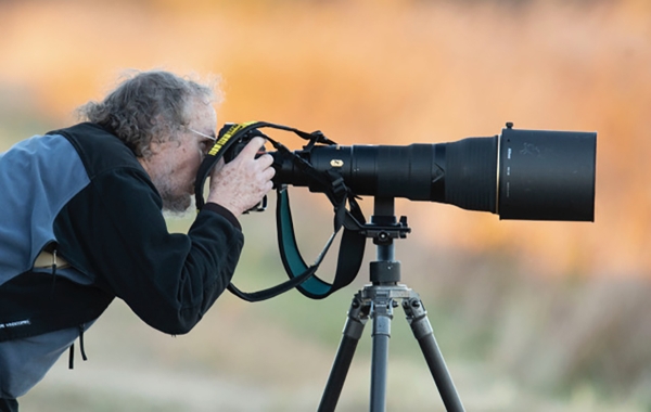 A photographer taking pictures with a very large lens