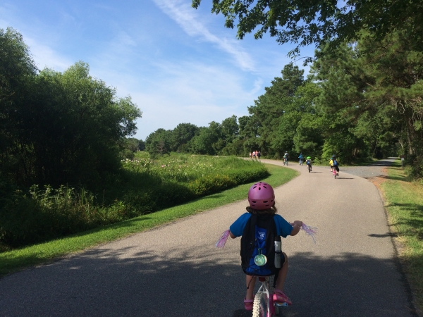 A child bikes along a paved trail