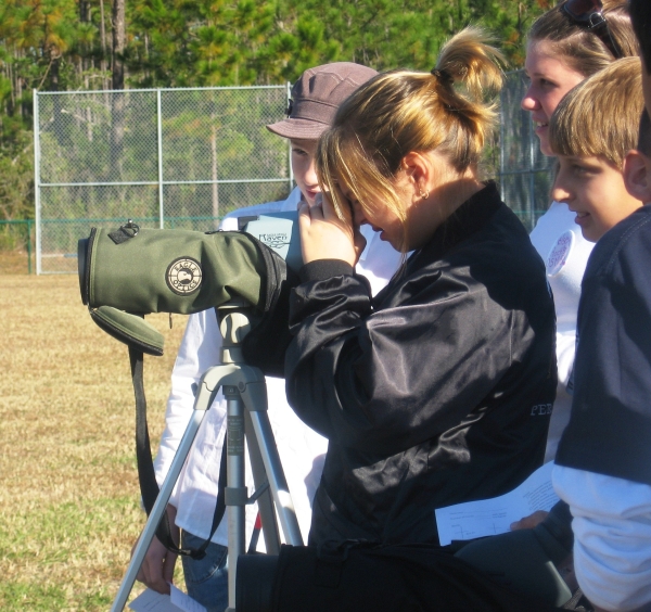 Students use a spotting scope to view Mississippi sandhill cranes.