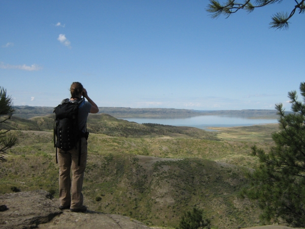 Hiker overlooking a lake in the distance.
