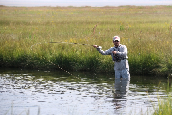Person fly fishing in creek