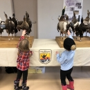 Two young participants engage with 'ducks on a stick' environmental education display