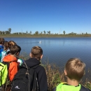 A class of students look out at a body of water.