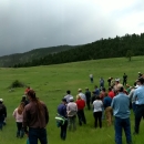 A large group of people standing in a grassy field.
