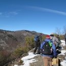 Group of people hiking a trail with a neighboring ridge in the background