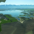 Arial view flying over Pablo Wildlife Refuge with the Mission Mountain Range in the background