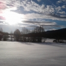 Snow covered hills at Little Pend Oreille National Wildlife Refuge, with sun streaming through scattered clouds. 