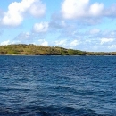 A small island in the distance surrounded by ocean water. 