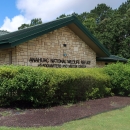 The Anahuac National Wildlife Refuge visitors center is shown with bushes in front.