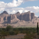 mountainous desert landscape with sparse green vegetation and tall mountains
