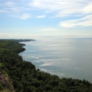 A forested coastline along a large lake.