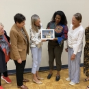 A group of six women admire the winning duck stamp artwork.