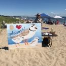 Intern conducts public outreach event at Rachel Carson NWR on a beach in Maine.