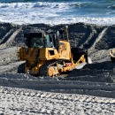 Bulldozer moving sand on a beach