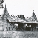 A structure that looks like two teepees connected by a roof with a stone fireplace in between.