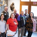 People smiling in front of wildlife exhibit.