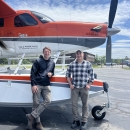 two pilot biologists standing by a plane