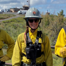 female firefighter stands in full protective gear