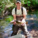 Fish Biologist, Kyle Beard, holding a salmonid 
