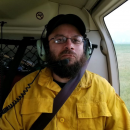 Man in yellow shirt sits in helicopter
