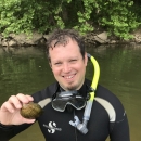 Headshot photo of Josh Hundley wearing snorkeling gear and holding a freshwater mussel by USFWS.