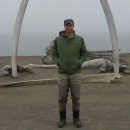 a man standing between two whale ribs 
