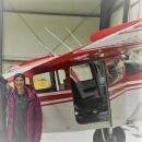 a woman by a plane in a hangar