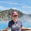 Person standing in front of hotsprings smiling at camera