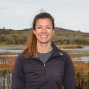 Sarah Markegard smiles surrounded by a wetland landscape.