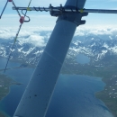 Image taken from a fixed-wing airplane over the landscape. A radio telemetry antenna can be seen on the fixed wing.