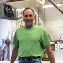 man from waist up, in a maintenance workroom