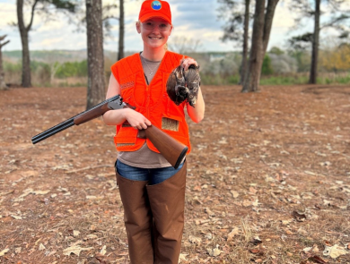 ACE Fellow Elena Campbell wearing blazing orange holds three quail she successfully harvested while hunting at Buckeyes Plantation. 