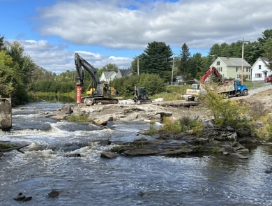 Construction equipment working on the side of a flowing river