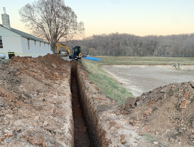 A trench being dug by an excavator for new pipelines at Mammoth Spring national Fish Hatchery.