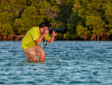 Ernesto Gomez taking photos of wildlife in a wetland