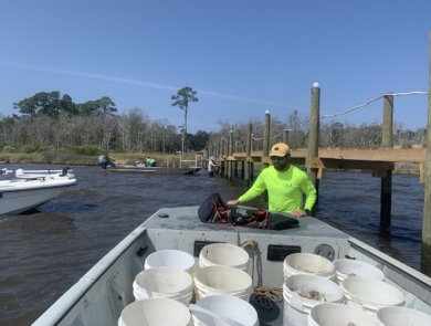 Biologist prepares boat with rock and oyster shell