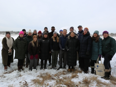 A smiling group stands in a frozen salt marsh
