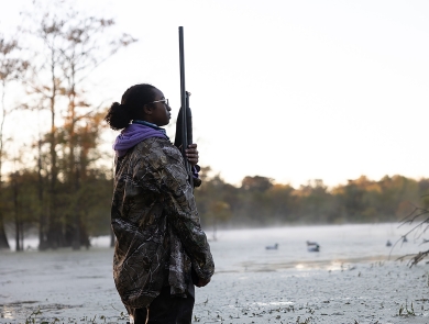 Young Woman In Hunting Gear Stands at Dusk-Wetlands