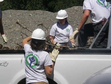 Youth Conservation Corp members loading brush into a truck