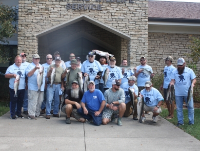 Wounded Warrior Fishing Derby participants holding stripers caught during the event