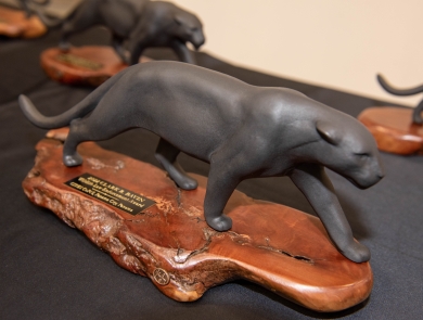 A statuette of a jaguar on a wooden pase