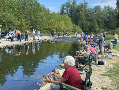 Elderly people fishing at stream