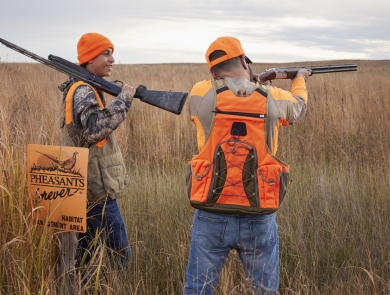 Father and son in hunter blaze orange vests.
